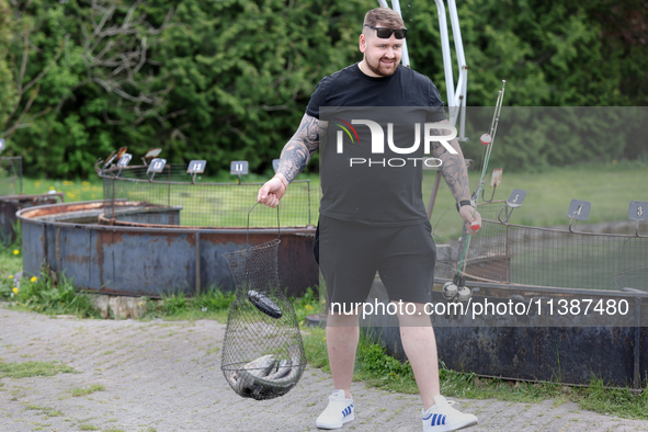 A man is holding a basket with freshly caught rainbow trout at a pond in Stouffville, Ontario, Canada, on May 12, 2024. 