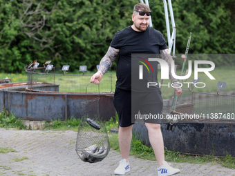 A man is holding a basket with freshly caught rainbow trout at a pond in Stouffville, Ontario, Canada, on May 12, 2024. (