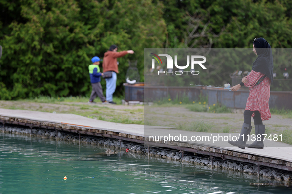 A woman is fishing for rainbow trout at a pond in Stouffville, Ontario, Canada, on May 12, 2024. 