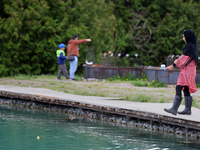 A woman is fishing for rainbow trout at a pond in Stouffville, Ontario, Canada, on May 12, 2024. (