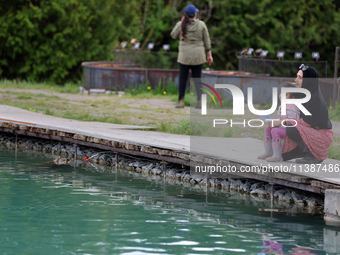 A woman and her daughter are fishing for rainbow trout at a pond in Stouffville, Ontario, Canada, on May 12, 2024. (