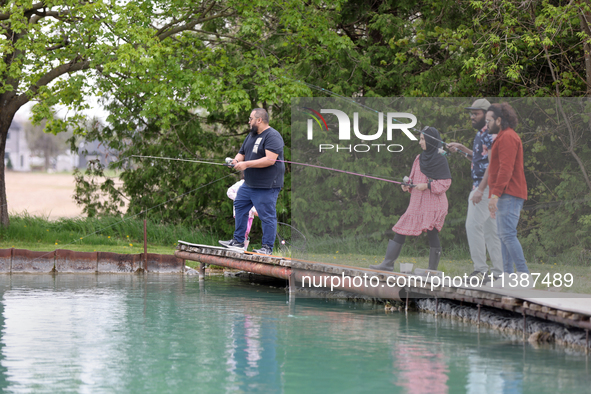 People are fishing for rainbow trout at a pond in Stouffville, Ontario, Canada, on May 12, 2024. 