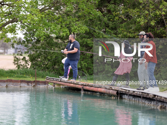 People are fishing for rainbow trout at a pond in Stouffville, Ontario, Canada, on May 12, 2024. (