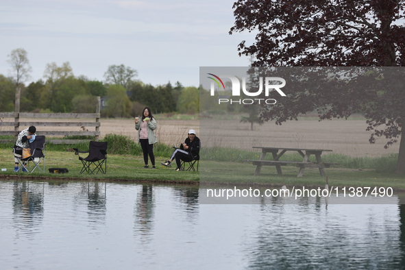 People are relaxing by a pond in Stouffville, Ontario, Canada, on May 12, 2024. 