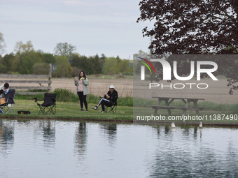 People are relaxing by a pond in Stouffville, Ontario, Canada, on May 12, 2024. (