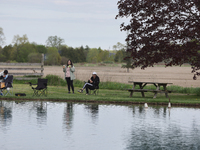 People are relaxing by a pond in Stouffville, Ontario, Canada, on May 12, 2024. (