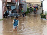 A man is crossing the flooded road in Tikathali, Kathmandu, on July 6, 2024, following incessant rainfall (