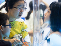 A visitor is taking a look at an emotion-synchronized face mask at the World Artificial Intelligence Conference at the Shanghai World Expo E...