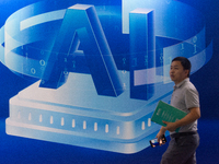 A visitor is walking past an AI sign at the World Artificial Intelligence Conference at the Shanghai World Expo Exhibition Center in Shangha...