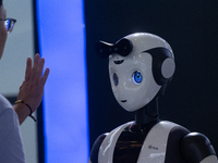 A visitor is interacting with a humanoid robot at the World Artificial Intelligence Conference at the Shanghai World Expo Exhibition Center...