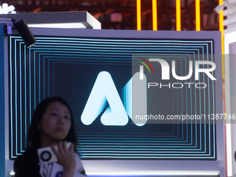 A visitor is walking past an AI sign at the World Artificial Intelligence Conference at the Shanghai World Expo Exhibition Center in Shangha...