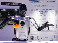 A humanoid robot is demonstrating how to pick up a ball at the World Artificial Intelligence Conference at the Shanghai World Expo Exhibitio...