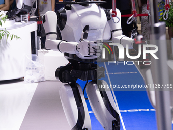 A humanoid robot is demonstrating how to walk and interact with people at the World Artificial Intelligence Conference at the Shanghai World...