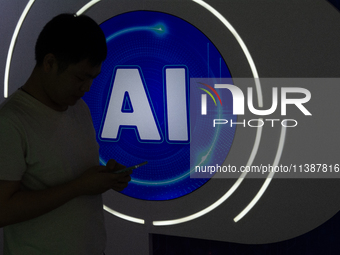 A visitor is walking past an AI sign at the World Artificial Intelligence Conference at the Shanghai World Expo Exhibition Center in Shangha...