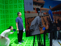 Visitors are standing in front of a green screen with AI backgrounds at the World Artificial Intelligence Conference at the Shanghai World E...