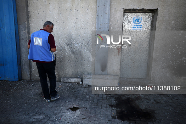 A man is working for the United Nations Relief and Works Agency (URNWA) and is staring at the blood of a victim at the entrance of the agenc...