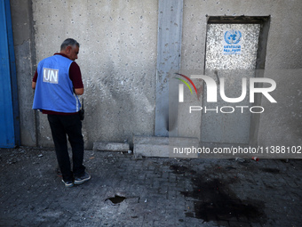 A man is working for the United Nations Relief and Works Agency (URNWA) and is staring at the blood of a victim at the entrance of the agenc...