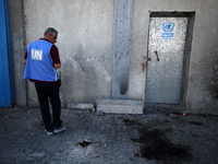 A man is working for the United Nations Relief and Works Agency (URNWA) and is staring at the blood of a victim at the entrance of the agenc...