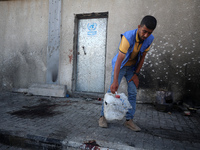 A man is working for the United Nations Relief and Works Agency (URNWA) and is removing a damaged object near the blood of a victim at the e...