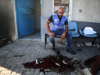 A man is working for the United Nations Relief and Works Agency (URNWA) and is staring at the blood of a victim at the entrance of the agenc...