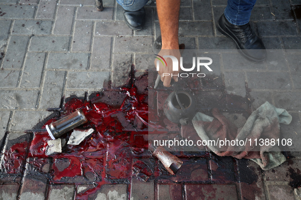 A man is working for the United Nations Relief and Works Agency (URNWA) and is staring at the blood of a victim at the entrance of the agenc...