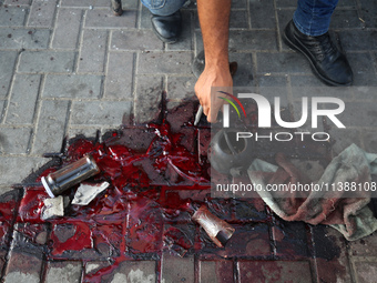 A man is working for the United Nations Relief and Works Agency (URNWA) and is staring at the blood of a victim at the entrance of the agenc...