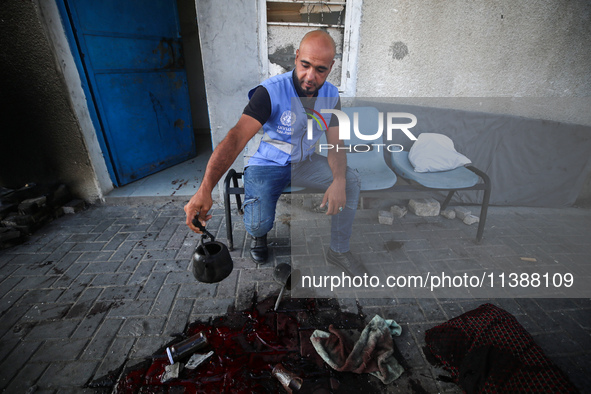 A man is working for the United Nations Relief and Works Agency (URNWA) and is staring at the blood of a victim at the entrance of the agenc...