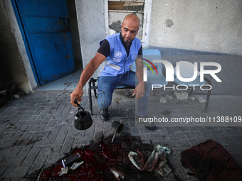 A man is working for the United Nations Relief and Works Agency (URNWA) and is staring at the blood of a victim at the entrance of the agenc...