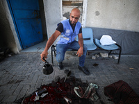 A man is working for the United Nations Relief and Works Agency (URNWA) and is staring at the blood of a victim at the entrance of the agenc...