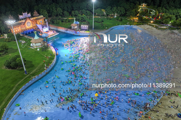 A large number of citizens are cooling off at a water park on the evening of high temperature in Nanjing, China, on July 6, 2024. 