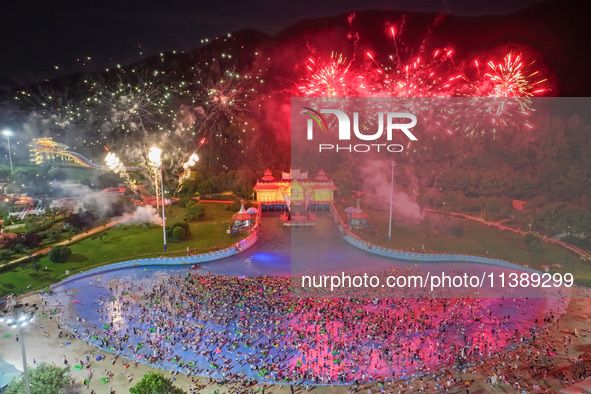 A large number of citizens are watching a fireworks show at a water park during high temperatures in Nanjing, China, on July 6, 2024. 