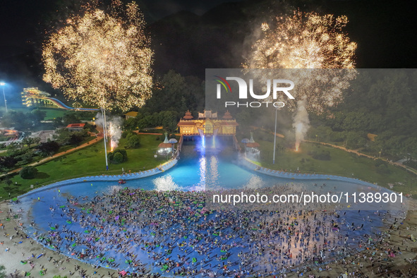 A large number of citizens are watching a fireworks show at a water park during high temperatures in Nanjing, China, on July 6, 2024. 