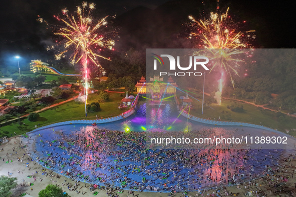 A large number of citizens are watching a fireworks show at a water park during high temperatures in Nanjing, China, on July 6, 2024. 