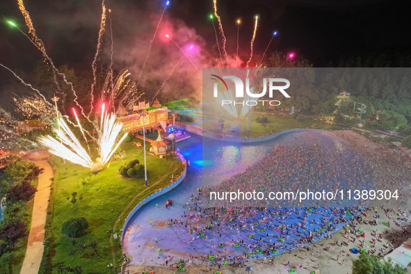 A large number of citizens are watching a fireworks show at a water park during high temperatures in Nanjing, China, on July 6, 2024. 