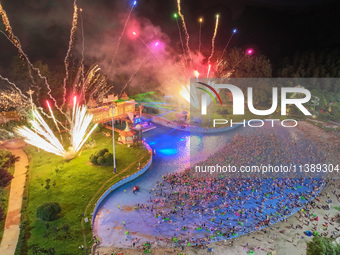 A large number of citizens are watching a fireworks show at a water park during high temperatures in Nanjing, China, on July 6, 2024. (