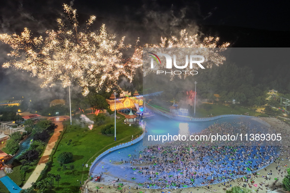 A large number of citizens are watching a fireworks show at a water park during high temperatures in Nanjing, China, on July 6, 2024. 