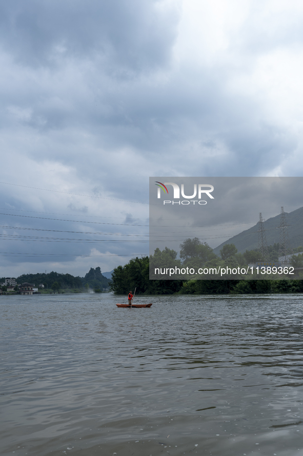 Security guards are patrolling the water as a power plant is opening a gate to release floodwater in Enshi, Hubei province, China, on July 6...