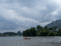 Security guards are patrolling the water as a power plant is opening a gate to release floodwater in Enshi, Hubei province, China, on July 6...