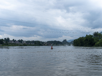 Security guards are patrolling the water as a power plant is opening a gate to release floodwater in Enshi, Hubei province, China, on July 6...