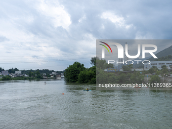 Security guards are patrolling the water as a power plant is opening a gate to release floodwater in Enshi, Hubei province, China, on July 6...