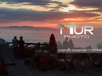 Tourists are watching the sunrise from a viewing platform over the Three Gorges in Yichang, China, on July 7, 2024. (