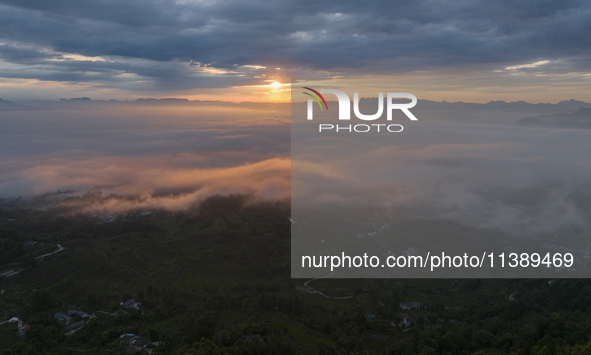 Tourists are watching the sunrise from a viewing platform over the Three Gorges in Yichang, China, on July 7, 2024. 