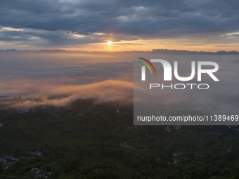 Tourists are watching the sunrise from a viewing platform over the Three Gorges in Yichang, China, on July 7, 2024. (