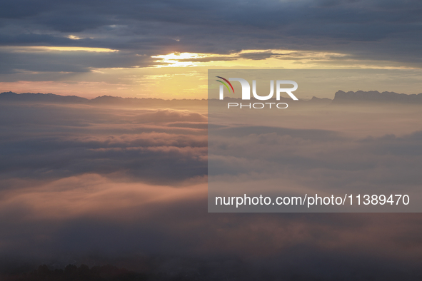 Tourists are watching the sunrise from a viewing platform over the Three Gorges in Yichang, China, on July 7, 2024. 