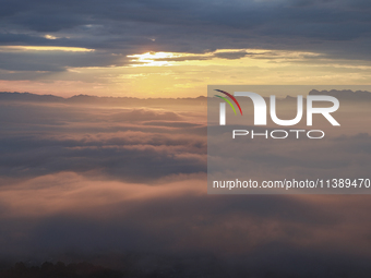 Tourists are watching the sunrise from a viewing platform over the Three Gorges in Yichang, China, on July 7, 2024. (