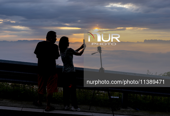 Tourists are watching the sunrise from a viewing platform over the Three Gorges in Yichang, China, on July 7, 2024. 