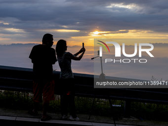 Tourists are watching the sunrise from a viewing platform over the Three Gorges in Yichang, China, on July 7, 2024. (