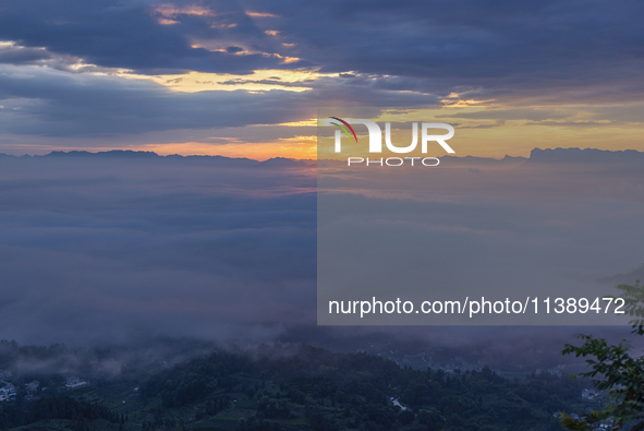 Tourists are watching the sunrise from a viewing platform over the Three Gorges in Yichang, China, on July 7, 2024. 