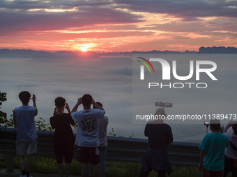 Tourists are watching the sunrise from a viewing platform over the Three Gorges in Yichang, China, on July 7, 2024. (