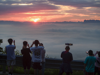 Tourists are watching the sunrise from a viewing platform over the Three Gorges in Yichang, China, on July 7, 2024. (